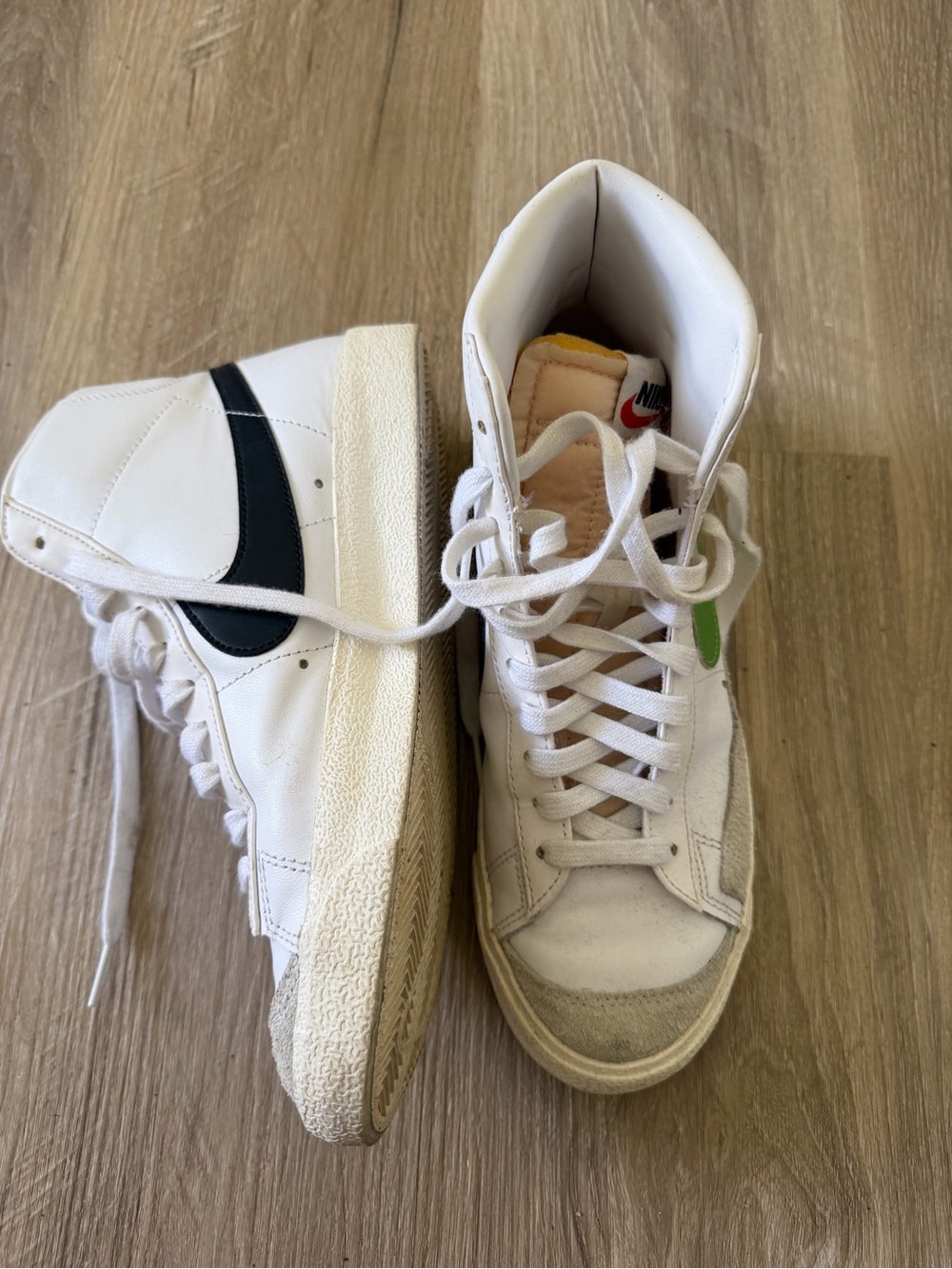 Nike White High-Top Sneakers with Black Swoosh and Green Tongue Tab